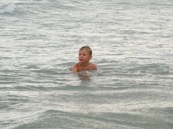 Kinderen zwemmen in de zee op het strand in Bibione, Italië — Stockfoto