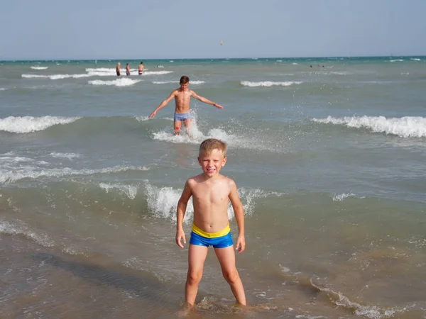 子供たちはイタリアのビビオネのビーチで海で泳ぐ — ストック写真