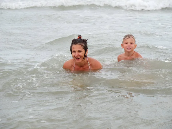 Mamma e figlio stanno nuotando nel mare. Bibione, Italia — Foto Stock