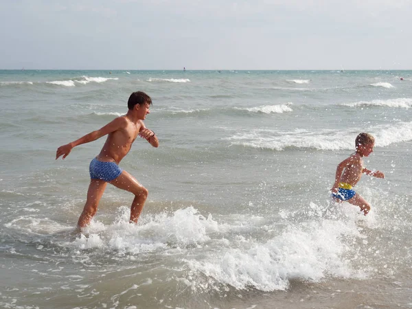 Crianças nadam no mar na praia em Bibione, Itália — Fotografia de Stock