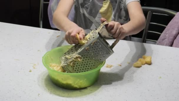 Junge bereitet Essen zu. reibt Kartoffeln — Stockvideo