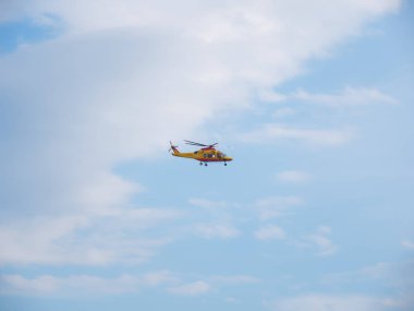 Mavi gökyüzünde bulutlu kurtarma helikopteri