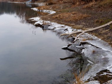 Soğuk sonbahar sabahı, göldeki ilk buz.