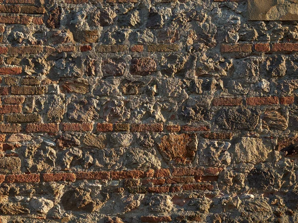 Stenen muur van de oude stad met groene wijnstokken — Stockfoto