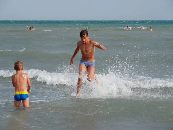 Crianças nadam no mar na praia em Bibione, Itália — Fotografia de Stock