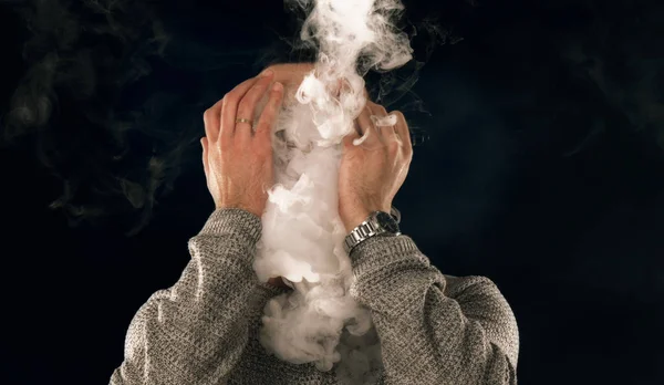 Smoking man in e-cigarette smoke on black background — Stock Photo, Image