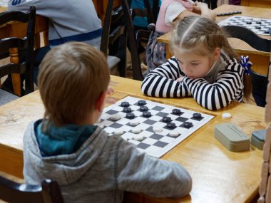 Gomel, Belarus - 29 Aralık 2019: Erkekler ve kızlar arasındaki satranç müsabakası.