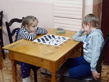 Gomel, Belarus - 29 Aralık 2019: Erkekler ve kızlar arasındaki satranç müsabakası.