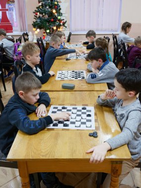 Gomel, Belarus - 29 Aralık 2019: Erkekler ve kızlar arasındaki satranç müsabakası.