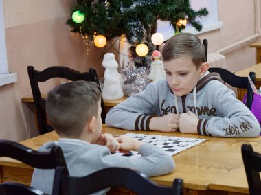 Gomel, Belarus - 29 Aralık 2019: Erkekler ve kızlar arasındaki satranç müsabakası.