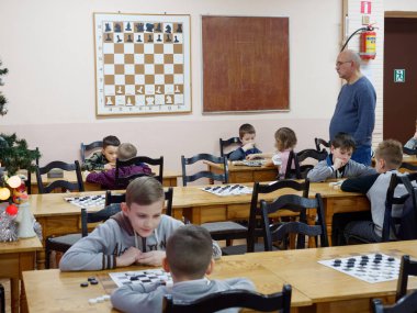 Gomel, Belarus - 29 Aralık 2019: Erkekler ve kızlar arasındaki satranç müsabakası.