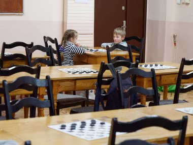 Gomel, Belarus - 29 Aralık 2019: Erkekler ve kızlar arasındaki satranç müsabakası.