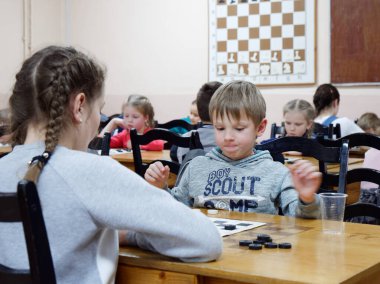 Gomel, Belarus - 29 Aralık 2019: Erkekler ve kızlar arasındaki satranç müsabakası.