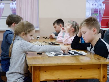 Gomel, Belarus - 29 Aralık 2019: Erkekler ve kızlar arasındaki satranç müsabakası.