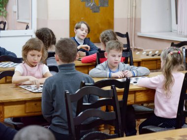 Gomel, Belarus - 29 Aralık 2019: Erkekler ve kızlar arasındaki satranç müsabakası.