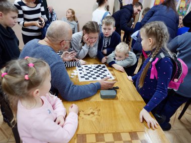 Gomel, Belarus - 29 Aralık 2019: Erkekler ve kızlar arasındaki satranç müsabakası.