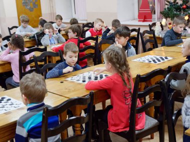 Gomel, Belarus - 29 Aralık 2019: Erkekler ve kızlar arasındaki satranç müsabakası.