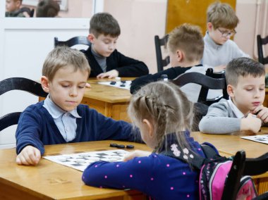Gomel, Belarus - 29 Aralık 2019: Erkekler ve kızlar arasındaki satranç müsabakası.