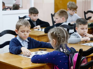 Gomel, Belarus - 29 Aralık 2019: Erkekler ve kızlar arasındaki satranç müsabakası.