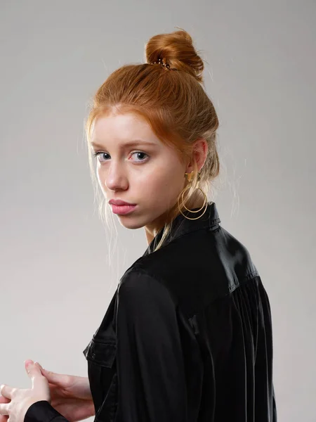 Chica joven con el pelo largo y rojo sobre un fondo gris — Foto de Stock