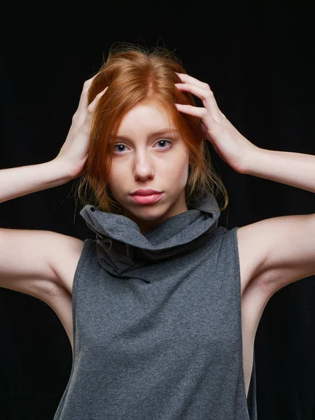 Chica joven con el pelo largo y rojo sobre un fondo negro —  Fotos de Stock