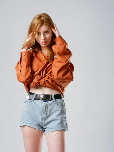 Chica joven con el pelo largo y rojo sobre un fondo gris — Foto de Stock