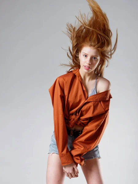 Jong meisje met lang rood haar op een grijze achtergrond — Stockfoto