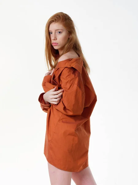 Ung flicka med löst långt rött hår på en vit bakgrund — Stockfoto