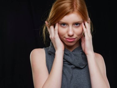 Siyah arka planda uzun kızıl saçlı genç bir kız.