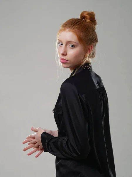 Chica joven con el pelo largo y rojo sobre un fondo gris — Foto de Stock