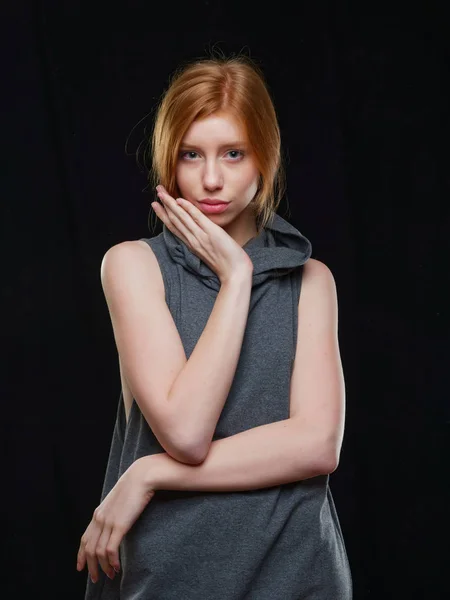 Jong meisje met lang rood haar op een zwarte achtergrond — Stockfoto