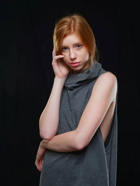 Chica joven con el pelo largo y rojo sobre un fondo negro — Foto de Stock