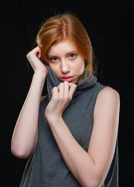 Chica joven con el pelo largo y rojo sobre un fondo negro — Foto de Stock