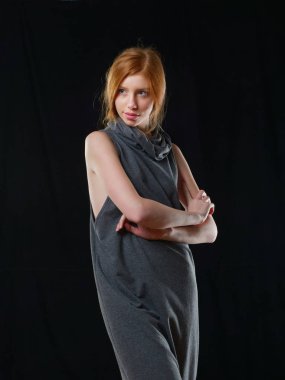 Siyah arka planda uzun kızıl saçlı genç bir kız.