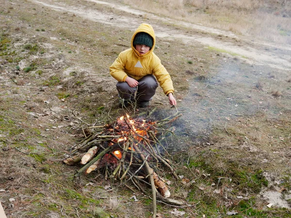 Boy prepare food on a campfire in nature — Stock Photo, Image