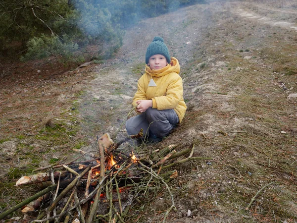 Çocuk doğada bir kamp ateşinde yemek hazırlıyor. — Stok fotoğraf