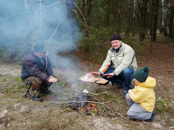 Anne ve oğul doğada bir kamp ateşinde yemek hazırlıyorlar. — Stok fotoğraf