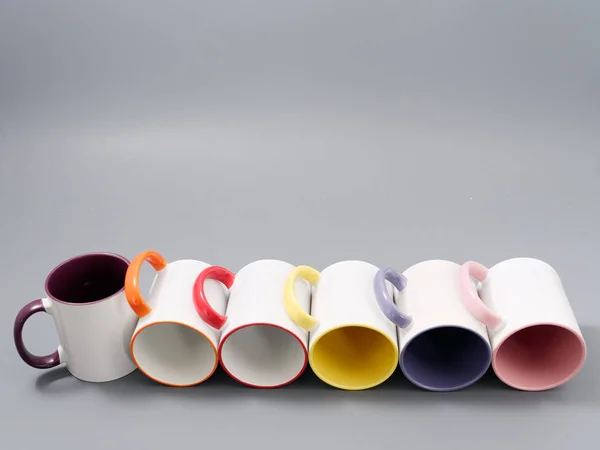 Farbige Tassen zur Sublimation in Komposition auf grauem Hintergrund — Stockfoto