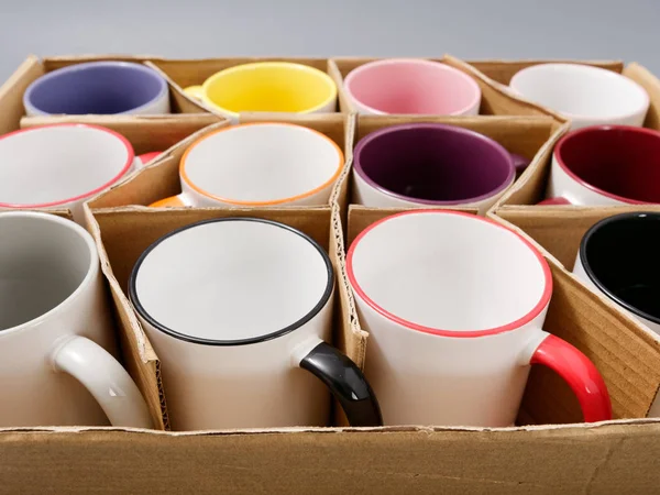 Tasses colorées pour la sublimation dans la composition sur un fond gris — Photo