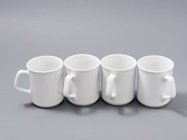 Gri arkaplandaki kompozisyonda yücelik için beyaz bardaklar