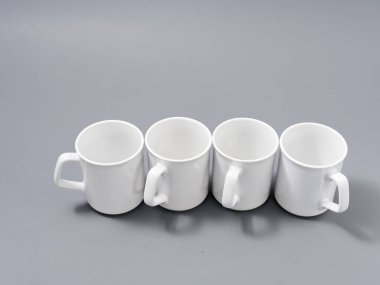 Gri arkaplandaki kompozisyonda yücelik için beyaz bardaklar