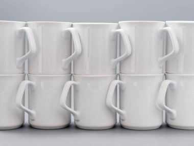 Gri arkaplandaki kompozisyonda yücelik için beyaz bardaklar