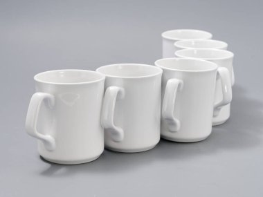 Gri arkaplandaki kompozisyonda yücelik için beyaz bardaklar