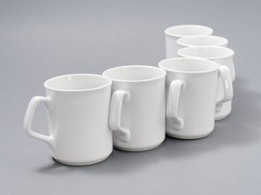 Gri arkaplandaki kompozisyonda yücelik için beyaz bardaklar