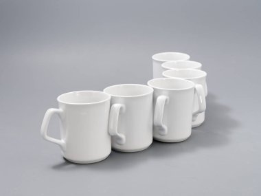 Gri arkaplandaki kompozisyonda yücelik için beyaz bardaklar