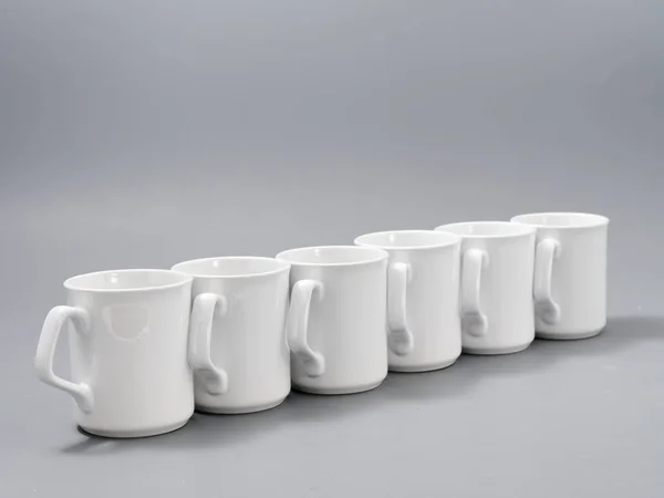 White cups for sublimation in composition on a gray background — Stock Photo, Image