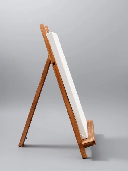 Ezel gemaakt van houten tafel op een grijze achtergrond — Stockfoto
