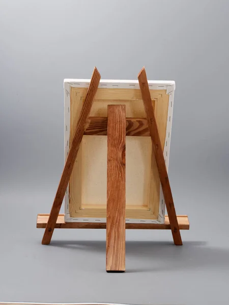 Easel made of wood table on a gray background — 스톡 사진