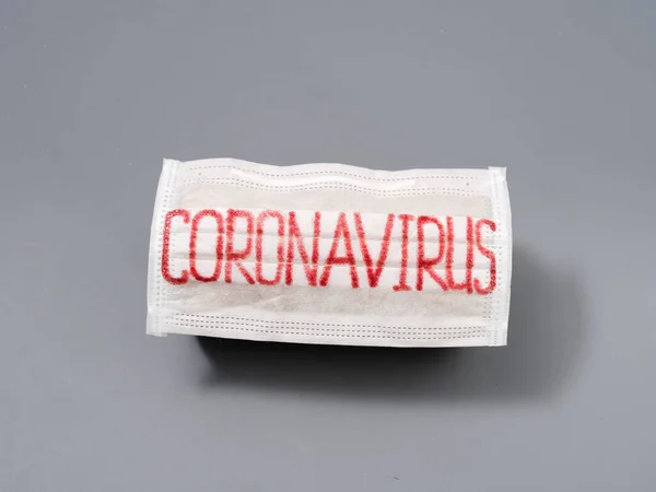 Antivirale Gesichtsmaske auf grauem Hintergrund. Coronavirus-Epidemie. — Stockfoto