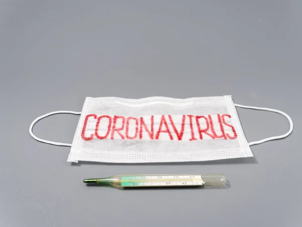 Antivirale Gesichtsmaske auf grauem Hintergrund. Coronavirus-Epidemie. — Stockfoto